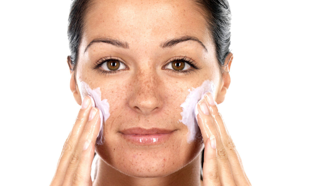 woman exfoliates face