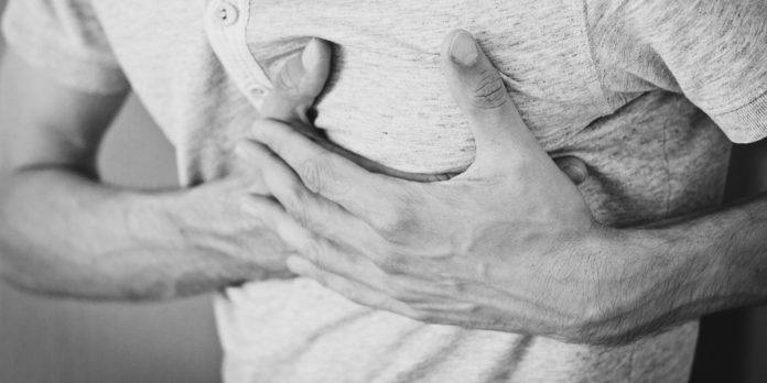 A picture of a man holding his left chest region