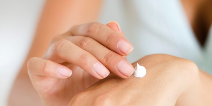 A lady applying body lotion