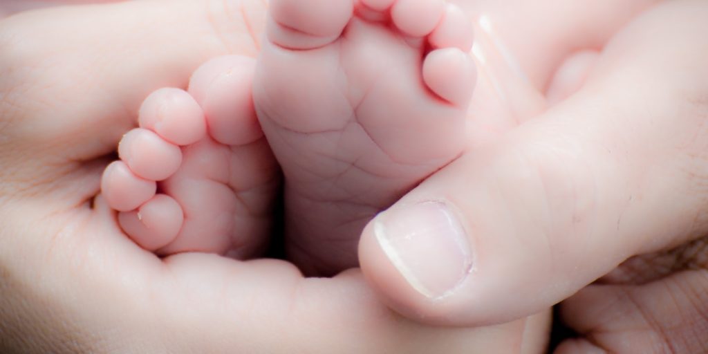 An image of someone massaging a baby`s feet