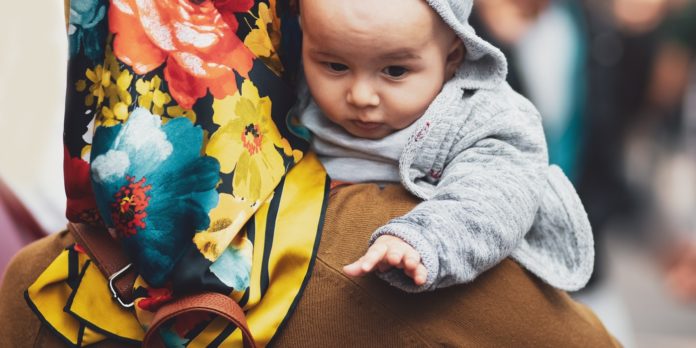 An image of a woman carrying a baby